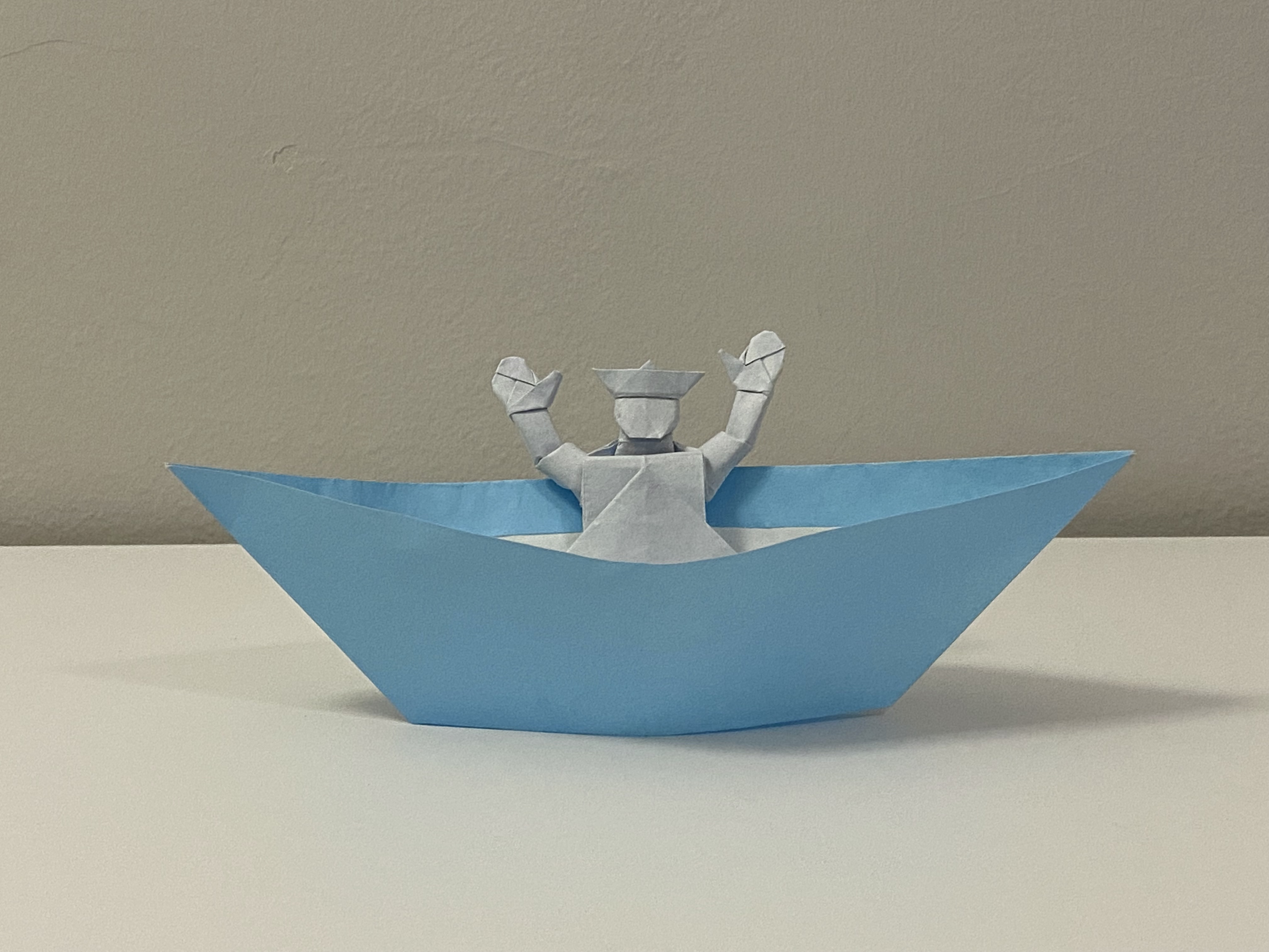 Origami boat and sailor.